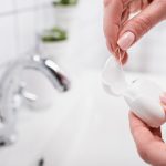 Partial,View,Of,Woman,Holding,Plastic,Container,With,Dental,Floss